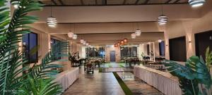 a lobby with tables and chairs and potted plants at Krishna Inn in Aurangabad