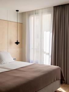New Hotel Opéra في باريس: غرفة نوم بسرير ونافذة كبيرة