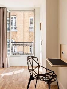 una silla negra en una habitación con ventana en New Hotel Opéra en París