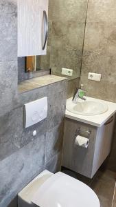 a bathroom with a white toilet and a sink at Skipalaekur Farm Apartments in Egilsstadir