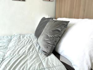 a bed with two gray pillows on top of it at City center + walk in closet in Cebu City