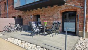 eine Terrasse mit einem Tisch, Stühlen und einem Fahrrad in der Unterkunft Speicherresidenz N 0,1 in Barth