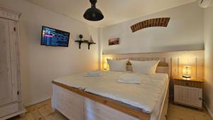 ein Schlafzimmer mit einem großen Bett mit weißer Bettwäsche in der Unterkunft Speicherresidenz N 0,1 in Barth