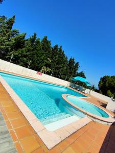 uma piscina com água azul em La Résidence Faraday em Carcassonne