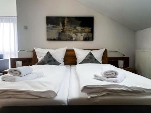 una camera con due letti e asciugamani bianchi di Ferienwohnung Haldennest a Bludenz