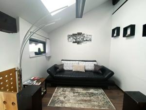 un soggiorno con divano in pelle nera in una camera di Ferienwohnung Haldennest a Bludenz