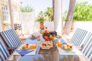 a table with plates of food and a bowl of fruit at Villa Dreams by Algarve Vacation in Guia
