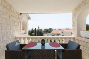 a table and chairs on a balcony with a view at Apartments Villa Nena in Bol