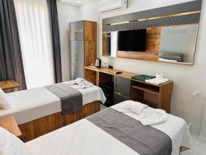 une chambre d'hôtel avec deux lits et un bureau dans l'établissement Efehan Otel, à Şanlıurfa