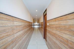 a hallway with wood panel walls and a hallway with a long corridor at FabHotel BNS Comforts in Bangalore