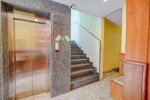 a lobby with a staircase and a glass door at FabHotel BNS Comforts in Bangalore