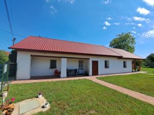 una pequeña casa blanca con techo rojo en Birs Vendégház Tiszafüred, en Tiszafüred