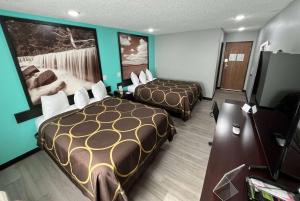 a hotel room with two beds and a flat screen tv at Super 8 by Wyndham Emporia in Emporia