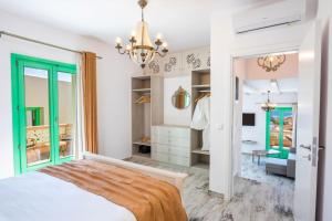 a bedroom with a bed and a chandelier at La Scala Luxury Villa Μikis Theodorakis with jacuzzi in Karpathos