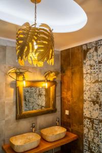 two sinks in a bathroom with a chandelier at La Scala Luxury Villa Μikis Theodorakis with jacuzzi in Karpathos Town