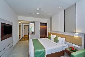 Habitación de hotel con cama y TV en Abad Fort, en Kochi