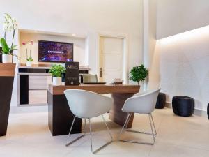 an office with a desk and two white chairs at Mercure Napoli Centro Angioino in Naples