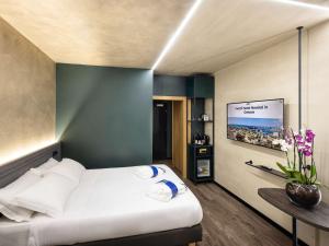 a bedroom with a bed and a flat screen tv at Novotel Genova City in Genoa