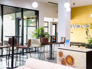 un hall avec des chaises et des tables dans un bâtiment dans l'établissement Pullman Abidjan, à Abidjan