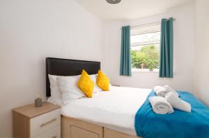 Un dormitorio con una cama grande con almohadas amarillas y blancas en Modern 2BR Apt Contractor stay en Hinckley