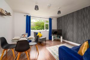Modern 2BR Apt Contractor stay في هينكلي: غرفة معيشة مع أريكة زرقاء وطاولة
