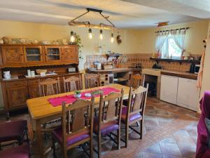 a kitchen with a wooden table and some chairs at Holiday House Nika in Vrbovsko