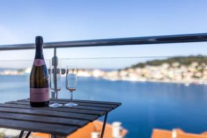 a bottle of wine sitting on a table with two glasses at Apartments Montevideo in Mali Lošinj