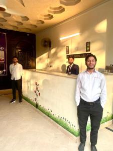 ラホールにあるHotel Royal Grandの三人の男が酒場の前に立っている