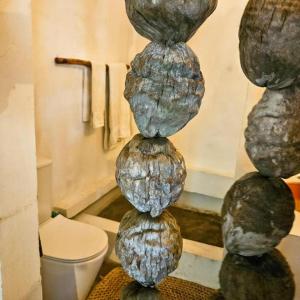 a stack of rocks in a bathroom with a toilet at Villas do Indico in Vilanculos