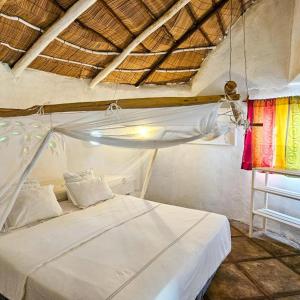 1 dormitorio con 1 cama blanca en una habitación en Villas do Indico en Vilanculos