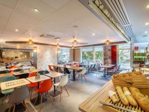 un restaurante con mesas y sillas y una cafetería en ibis Paris Vanves Parc des Expositions, en Vanves
