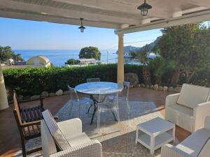 un patio con mesa, sillas y el océano en Maridea - Villetta Brezza Marina, en Ponza