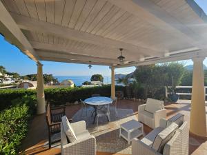 pérgola blanca con sillas y mesa en el patio en Maridea - Villetta Brezza Marina, en Ponza