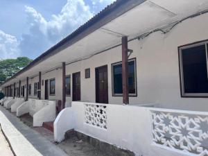 un edificio blanco con una fila de ventanas en OYO 90981 Chenang Rest House 1 en Pantai Cenang