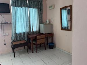 um quarto com uma secretária, um micro-ondas e um espelho. em OYO 90981 Chenang Rest House 1 em Pantai Cenang