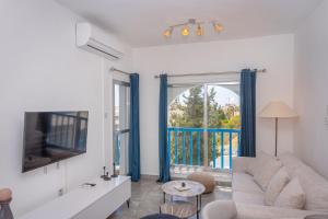 a living room with a couch and a tv at White Arches Apt #2 by TrulyCyprus in Limassol