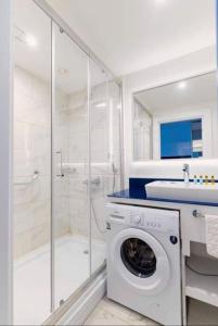 y baño blanco con lavadora y ducha. en Blue sea view blue orbi, en Batumi
