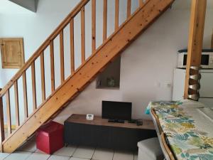 a room with a bed and a desk under a staircase at Au coeur des Volcans d'Auvergne in Ceyssat