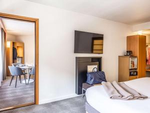 Habitación de hotel con cama y espejo en Novotel Lille Centre Gares en Lille