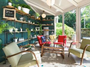 um quarto com cadeiras e uma mesa e prateleiras com plantas em ibis Nantes Saint Herblain em Saint-Herblain