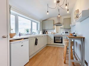 une cuisine avec des placards blancs et une table en bois dans l'établissement 3 Bed in Montrose 90784, à Inverkeilor
