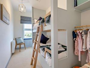Cette petite chambre comprend des lits superposés et une chaise. dans l'établissement 3 Bed in Montrose 90784, à Inverkeilor
