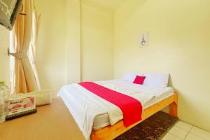 1 dormitorio pequeño con 1 cama con manta roja en RedDoorz near bandara City Mall, en Tangerang