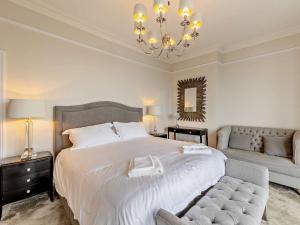 um quarto com uma grande cama branca e um lustre em 3 Bed in Aberdovey DY029 em Aberdyfi