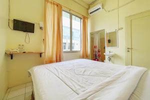 Habitación hospitalaria con cama y TV en RedDoorz near bandara City Mall, en Tangerang