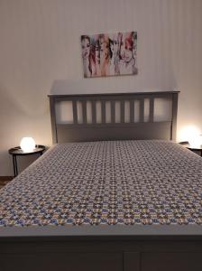 a bed in a bedroom with a picture on the wall at CASA SIRENETTA-Little Mermaid House in Lentini
