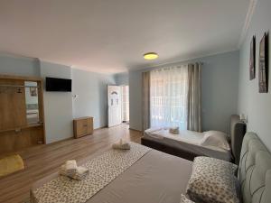 een woonkamer met twee bedden en een bank bij Kriss-Klej's Rooms in Sarandë