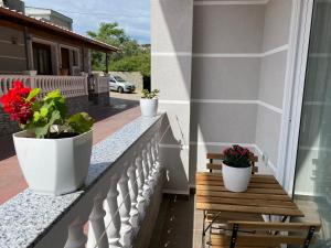 een balkon met twee potplanten en een houten bank bij Kriss-Klej's Rooms in Sarandë