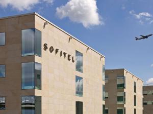a plane is flying over a building with an airport at Sofitel London Heathrow in Hillingdon