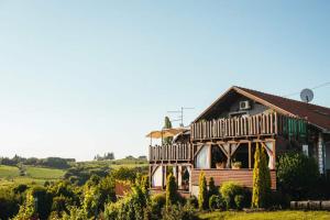 ein großes Holzhaus mit einer umlaufenden Veranda in der Unterkunft Holiday Home Bella Vita in Gornji Mihaljevec
